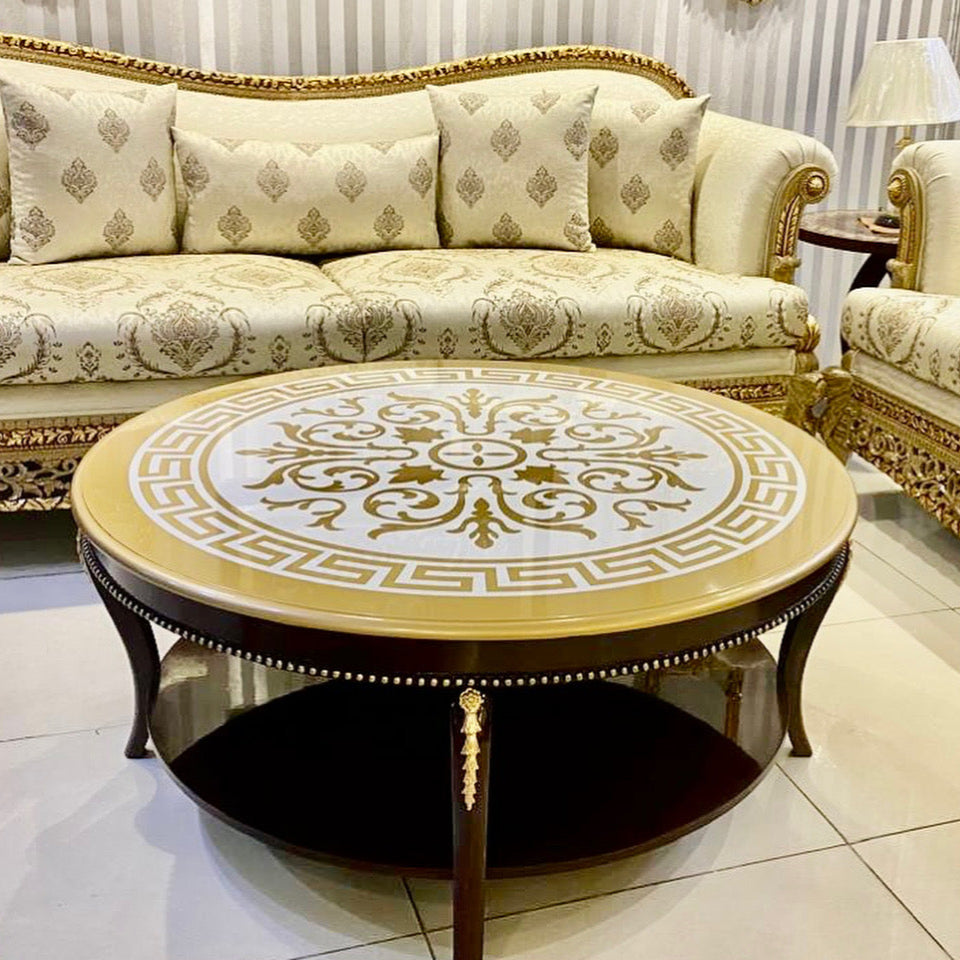 Decorative round coffee table with intricate design in a room with ornate furniture.